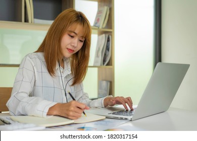 Business Women Keep Records Of Statistics And Company Profits In The Office To Prepare For Tomorrow Morning Meetings, Business Ideas And Note-taking.