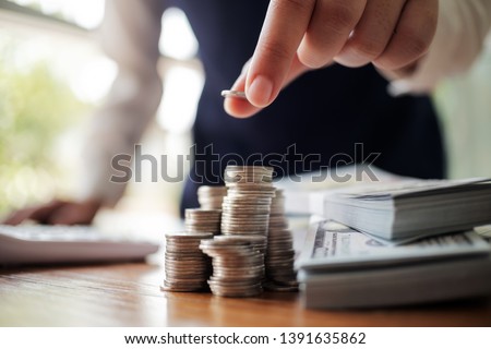 Business women put coin stack money and many bank note in office, Save money for future and Retirement. 