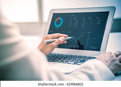 Business Women Reviewing Data In Financial Charts And Graphs