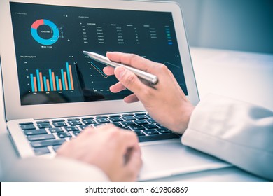 Business women reviewing data in financial charts and graphs - Shutterstock ID 619806869