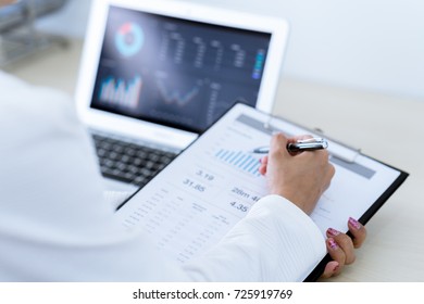 Business Women Reviewing Data In Financial Charts And Graphs