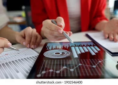 Business women studying charts and diagrams on digital tablet closeup. Business meetings concept