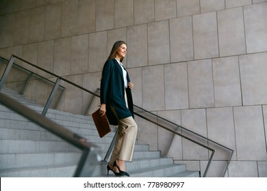Business Women Style. Woman Going To Work Walking Downstairs. Portrait Of Beautiful Smiling Female In Stylish Office Clothes Going Down Stairs. High Resolution.