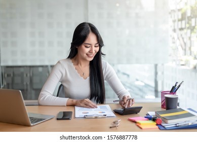 Business Women Using Calculator At Working With Financial Report.