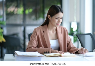 Business Women Using Calculator At Working With Financial Report.
