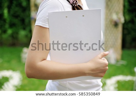 Young woman with glasses holding a laptop outdoors