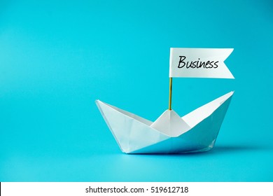BUSINESS word with boat paper on blue ocean background. Business conceptual.