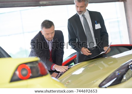 businessman about to buy a race car at car dealer