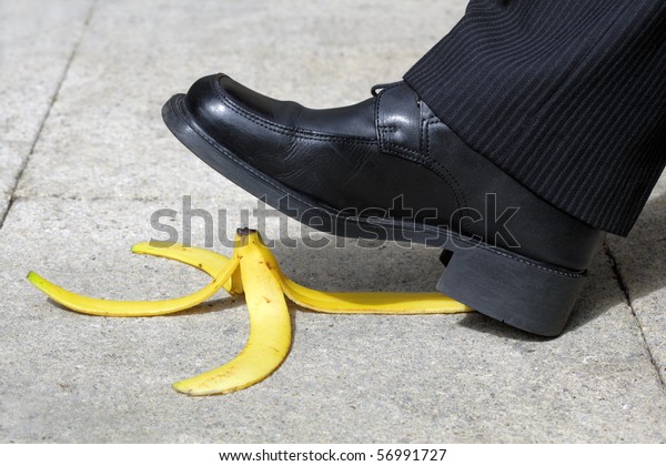 Businessman about\
to slip and fall on a banana\
skin