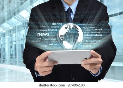 A businessman accessing internet and information technology via tablet / gadget in his hand
