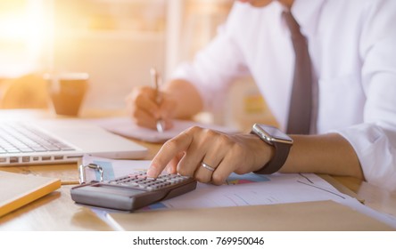 Businessman accountant using calculator and laptop for calculating finance on desk office. business financial accounting concept. - Shutterstock ID 769950046
