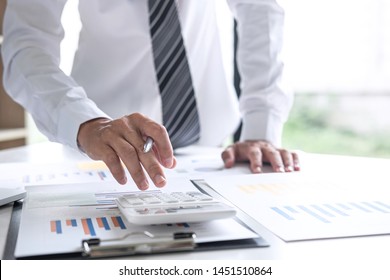 Businessman accountant working analyzing and calculating expense annual financial report balance sheet statement, doing finance making notes on report, Financing Accounting Banking Concept.