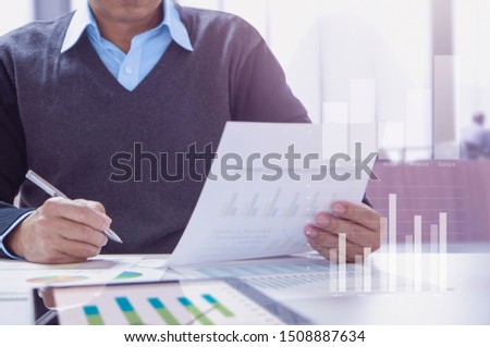 Businessman or accountant working in the office reviewing financial statements for business performace periodically.