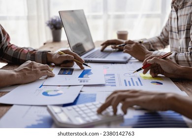 Businessman or accounting team analyzing graph data chart and laptop dashboard to prepare statistical reports and discuss financial data to analyze market data. Close-up image - Powered by Shutterstock