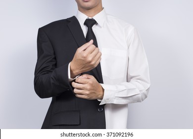 Businessman Adjusting Cufflinks his Suit - Powered by Shutterstock