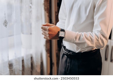 Businessman adjusting his watch, symbolizing precision and professionalism in a corporate setting - Powered by Shutterstock