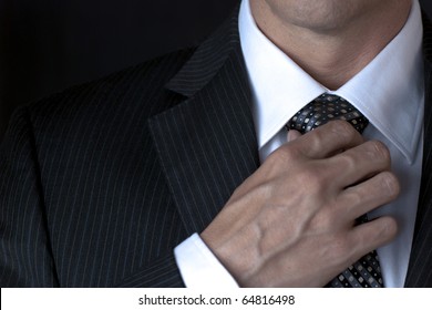 Businessman Adjusting Tie With Right Hand - Powered by Shutterstock