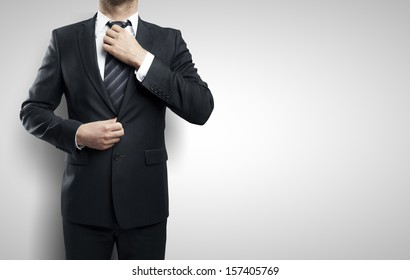 businessman adjusts his tie on white background - Powered by Shutterstock