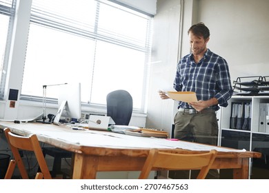 Businessman, admin and checking with folder for company finance, tax or report in office. Man, employee or administrator with documents, paperwork or file for backlog, expenses or financial records