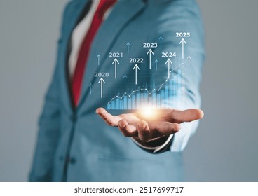 Businessman analyzes market growth trend graph in 2025 and plans business growth and profit increase. Calculates financial data for long-term investment. - Powered by Shutterstock