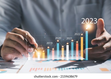 Businessman analyzes profitability of working companies with digital augmented reality graphics, positive indicators in 2023, businessman calculates financial data for long-term investments. - Shutterstock ID 2159638679