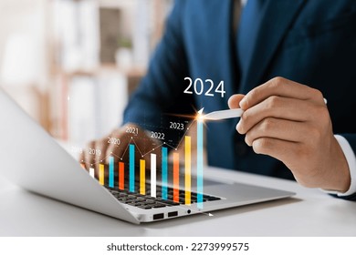 Businessman analyzes profitability of working companies with digital augmented reality graphics, positive indicators in 2024, businessman calculates financial data for long-term investments. - Shutterstock ID 2273999575