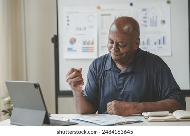 Businessman analyzing data reports on laptop at office desk. Professional work environment, charts and graphs displayed. - Powered by Shutterstock