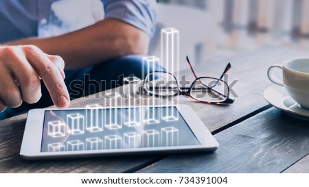 Businessman analyzing growing 3D AR chart floating above digital tablet computer screen, showing successful increase in business profit