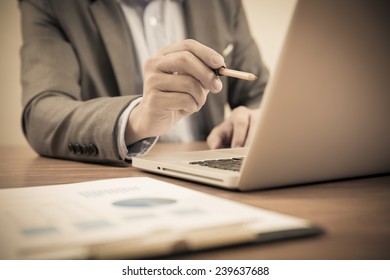 Businessman analyzing investment charts with laptop. Accounting - Shutterstock ID 239637688