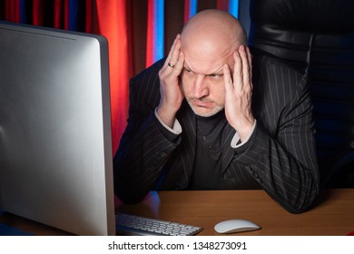 Businessman angrily looks at the computer monitor. The man is angry. Businessman in a suit. Bad business. Stern look. The bad news. - Shutterstock ID 1348273091