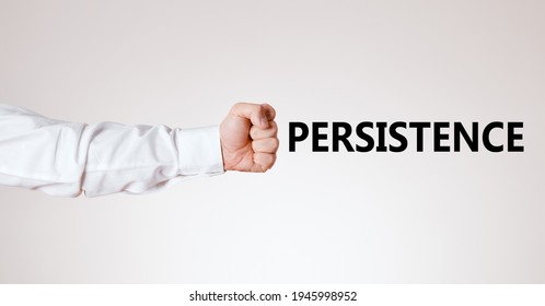 Businessman Arm With Hand As A Clenched Fist Points Towards The Word Persistence. Determination, Strength And Persistence In Business

