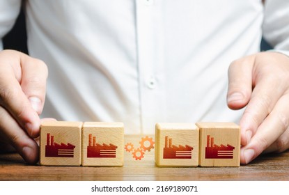 Businessman arranges work between factory productions. Industrial conglomerates and economic clusters. Collaboration and communication when working on large projects. Business globalization - Shutterstock ID 2169189071