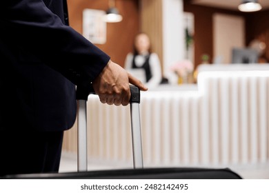 Businessman arriving in hotel lobby with suitcase, travelling for work meetings and conferences. Young adult entering reception area to do check in and relax, accommodation. Close up. - Powered by Shutterstock