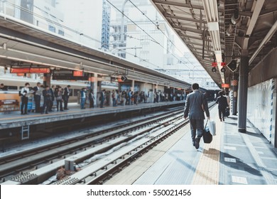 businessman arriving at the train station in the morning sunlight and going to work in the city. selective focus, vintage photo and film style. - Shutterstock ID 550021456