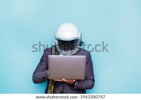 Businessman with astronaut helmet using a laptop