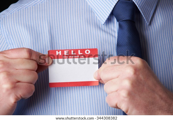 Businessman Attaching\
Name Tag At\
Conference