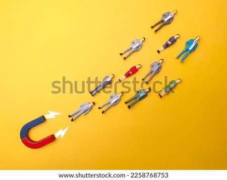 Businessman attracts by magnet on a yellow background. Business and leadership concept.