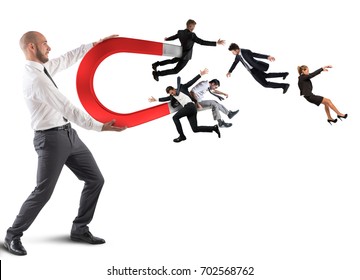Businessman attracts people with a big magnet - Shutterstock ID 702568762
