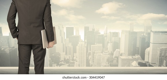 Businessman From The Back In Front Of A City View On The Window 