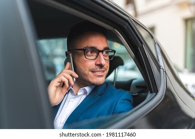 Businessman In The Back Seat Of A Taxi Having Phone Call. Spanish Business Man Using Phone In The Car. Business Concept.