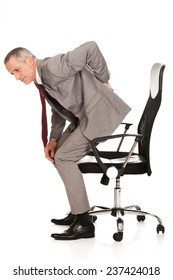 Businessman With Backache Standing Up From A Chair.