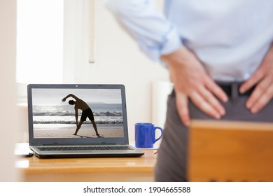 Businessman With Backache Standing In Front Of Laptop While Working From Home - Same Model On The Screen And In The Foreground