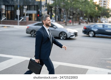 Businessman with backpack walking in city. Side view of male entrepreneur in classy suit and with takeaway drink walking along crosswalk while commuting to work in morning. businessman in the street - Powered by Shutterstock