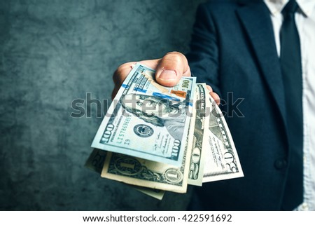 Businessman from bank offering money loan in USA dollar banknotes, selective focus.