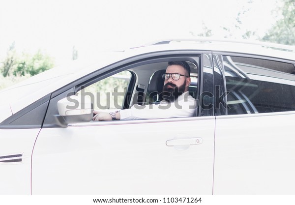 businessman with a\
beard in a expensive car,\
busy