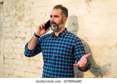 Businessman With A Beard Having Conflict While Talking With Someone On The Phone.