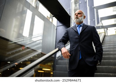 Businessman with a beard is riding an escalator and looking into the distance, lost in thought, as he travels to his destination - Powered by Shutterstock