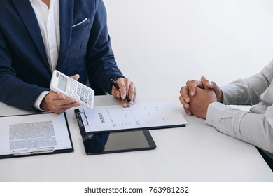 Businessman being analysis and making the decision a car insurance policy, Agent man is using calculator to presentation detail and waiting for his reply to finish.