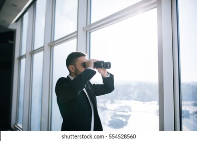 Businessman With Binoculars Spying On Competitors.