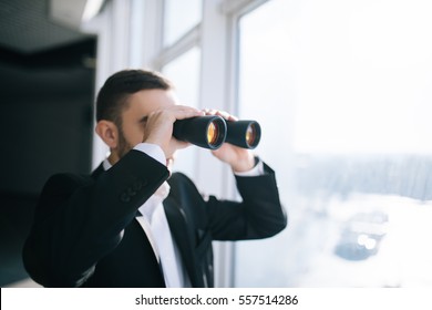 Businessman With Binoculars Spying On Competitors.